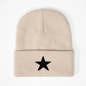 Close-up of beige knit beanie with black embroidered star on the folded brim