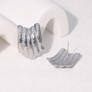 Detailed view of silver stainless steel earrings with textured ribbed metal design