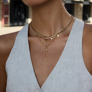 Détail du collier multi-rangs doré avec pendentifs étoile et croix en acier inoxydable