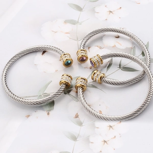 Close-up of twisted rope cable bangles with gold accents and colorful crystal settings