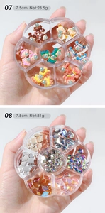 Detailed close-up of mixed nail art charms with resin bears and rhinestones in flower cases