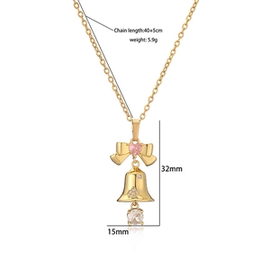 Détail du collier cloche dorée avec zircon cœur rose et ornements en cristal