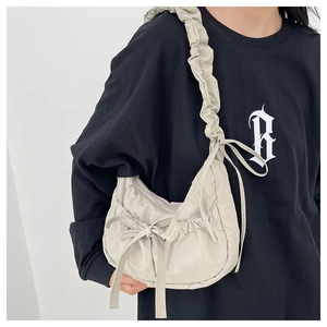 Detail of ruffled nylon shoulder bag with drawstring bow and crescent moon shape