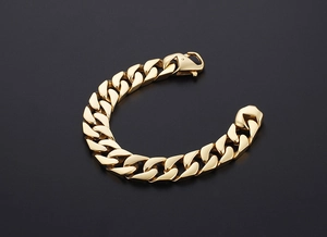 Vue macro d'un bracelet gourmette doré poli montrant la texture métallique brillante