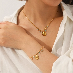 Golden ocean theme jewelry set featuring shell and star charms worn on a white shirt