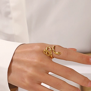 Bague serpent minimaliste en acier inoxydable doré portée sur un fond de chemise blanche