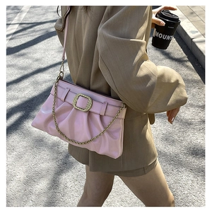 Détail du sac sous l'aisselle en cuir plissé rose avec boucle dorée et chaîne