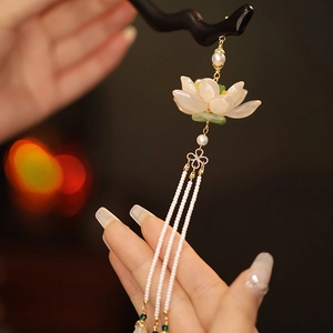 Dettaglio di forcina in legno con fiore di loto bianco e nappe di perle lunghe pendenti