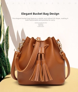 Detailed view of caramel PU leather bucket bag featuring tassels and drawstring closure