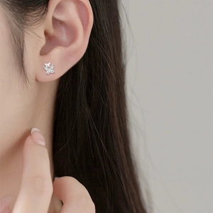 Elegant silver butterfly stud earrings with sparkling cubic zirconia on a model's ear