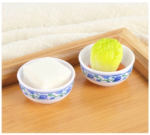 Detailed macro shot of miniature dollhouse tofu and cabbage dishes in porcelain bowls