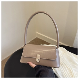 Detailed close-up of khaki leather shoulder bag with elegant gold metal clasp