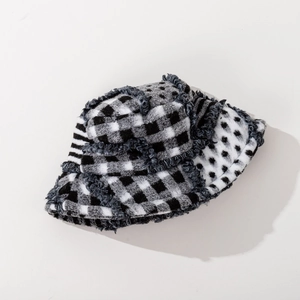 Close-up detail of black and white plaid wool tweed bucket hat with frayed edges texture
