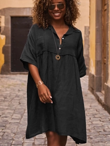 Close-up of black cotton-linen loose shirt dress featuring a classic buttoned polo collar