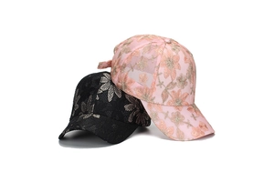 Close-up of black lace and pink floral embroidery textures on stylish baseball caps