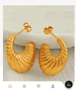 Macro shot of gold textured croissant hoop earrings with elegant spiral pattern detail