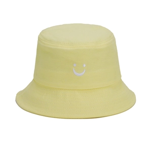 Detailed view of the smile face embroidery and neat stitching on light yellow bucket hat