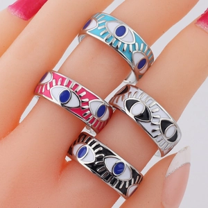 Detail of adjustable evil eye rings in sky blue, white, and pink enamel finishes