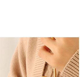 Close-up of gold textured ring worn with beige knit sweater for an elegant jewelry style