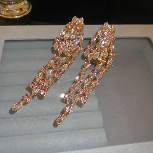 Detail of pink and champagne crystal tassel earrings with sparkling stone inlay