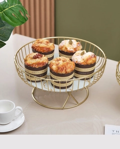 Close-up of golden iron cake stand with marble pattern tray and cupcakes in a luxury setting