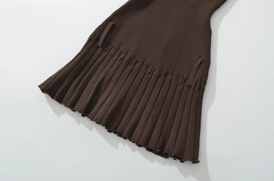 Detailed close-up of brown knitted pleated mini skirt showing fabric texture and hem