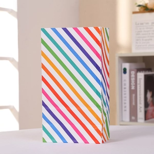 Upright colorful rainbow striped kraft paper treat bag for parties and gift packaging