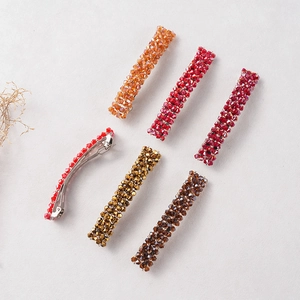 Lot de 6 barrettes en cristal aux tons chauds orange et doré sur fond texturé beige