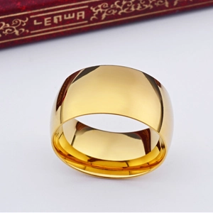 Macro view of gold-colored wide band ring with polished mirror finish and smooth metal texture