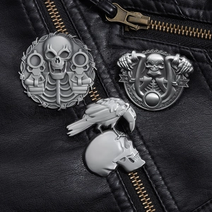 Detail of gothic dark punk badges with skull and raven motifs on black leather jacket