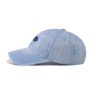 Detailed side view of washed blue denim baseball cap with embroidery and distressed holes