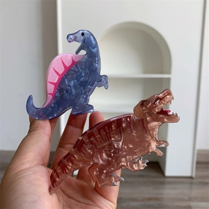 Close-up of cute dinosaur claw clips in blue and brown marble acrylic texture