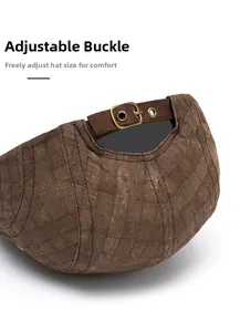 Close-up of adjustable strap and vintage copper buckle on quilted brown flat cap back