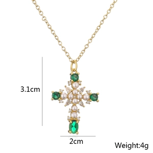 Detail view of 18K gold cross pendant with green stones and pearls measuring 3.1x2cm