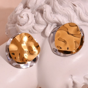 Detail shot of dual-tone wavy earrings on a classic statue showing gold and silver metallic texture