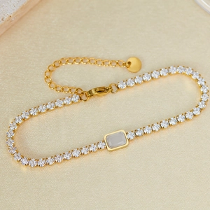 Detail of gold-plated tennis bracelet with zircon stones and rectangular centerpiece