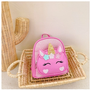 Detailed shot of pink unicorn backpack featuring glitter sequins and rainbow star patches