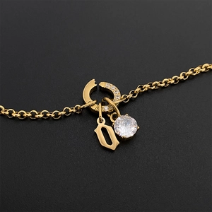Collier en acier inoxydable doré avec une lettre 'o' gothique et pendentif en CZ.