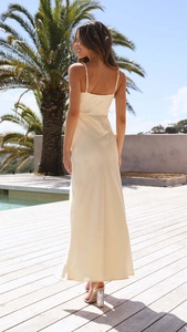 Detailed back view of a champagne satin slip dress featuring thin straps and backless design