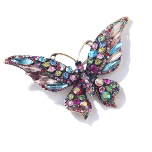 Vintage gold butterfly brooch with vibrant colorful crystals on a white background