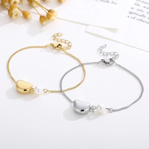 Détail de bracelets dorés et argentés avec perles et breloques en métal en duo