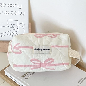 Quilted cotton cosmetic bag with pink bow pattern and the jolly house fabric label
