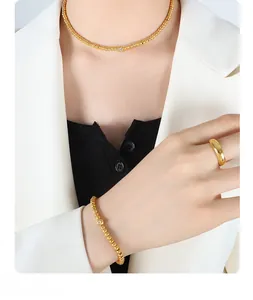Polished gold-plated beaded necklace and bracelet set with zircon charm on model