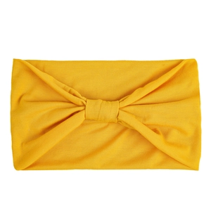 Macro view of bright yellow elastic wide-brimmed yoga headband with a knotted texture