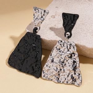 Detailed macro view showing the unique lava texture and asymmetric enamel finish of the earrings