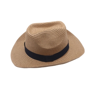 Vue détaillée du chapeau de paille d'été, montrant la texture tissée et le ruban noir.