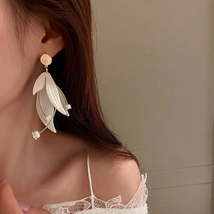 Elegante weiße Maiglöckchen-Ohrringe mit goldenem Stiel an einem Model getragen
