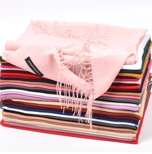 Detailed texture of colorful cashmere scarves with focus on the fabric label