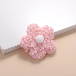 Close-up of a soft pink teddy velvet double-sided flower accessory with white plush center
