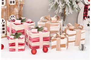 Detail of pink and white velvet Christmas gift boxes with bows in a snowy setting